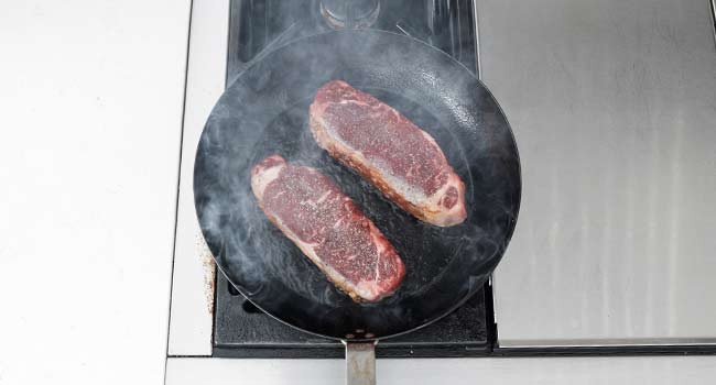 cooking steaks in a pan