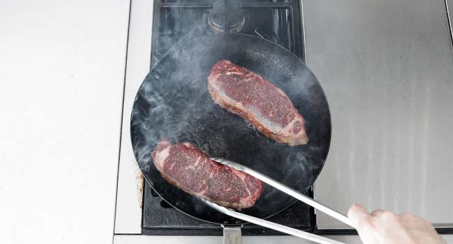 moving steaks in a pan