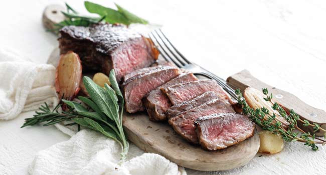 slicing steak with herbs and garlic