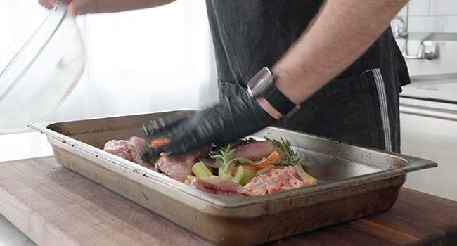 adding veggies to a roasting pan