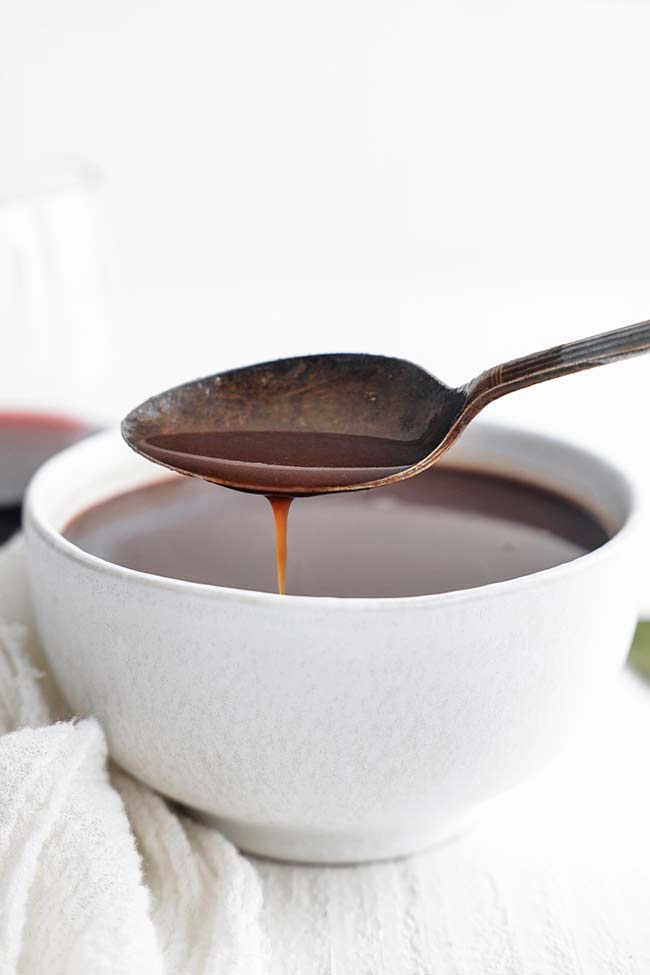 pouring bordelaise sauce into a bowl