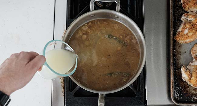 adding chicken stock to a pan