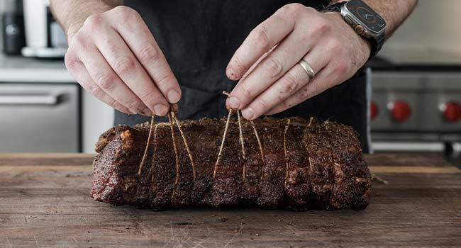 removing the butcher's twine from a smoked strip roast