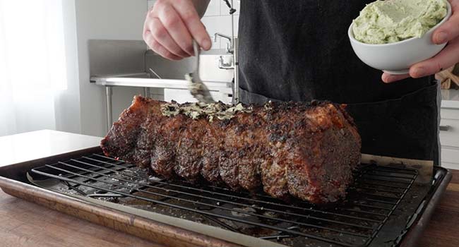 adding butter to a strip roast