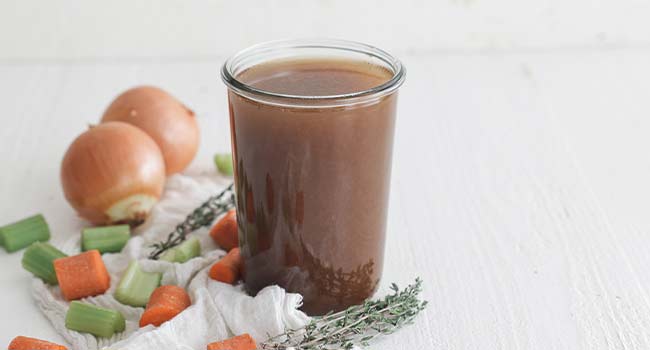 brown veal stock in a glass jar