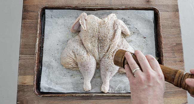 seasoning a flattened chicken