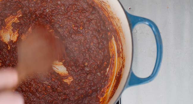 adding pepper sauce to a pot