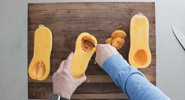 scooping out the seeds from butternut squash