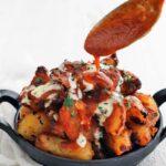 adding sauce to patatas bravas