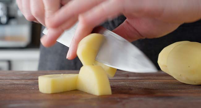 slicing potatoes into small wedges