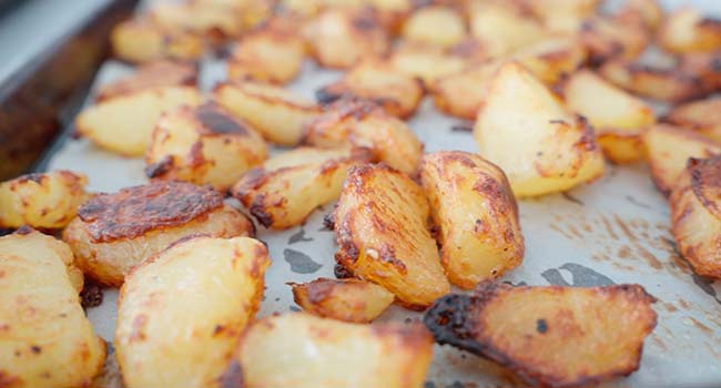 flipping potatoes over to roast in the oven