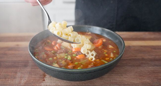 adding cooked pasta to soup