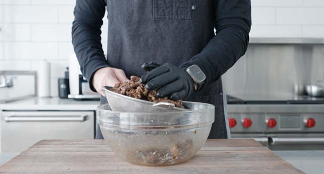 draining marinated beef slices