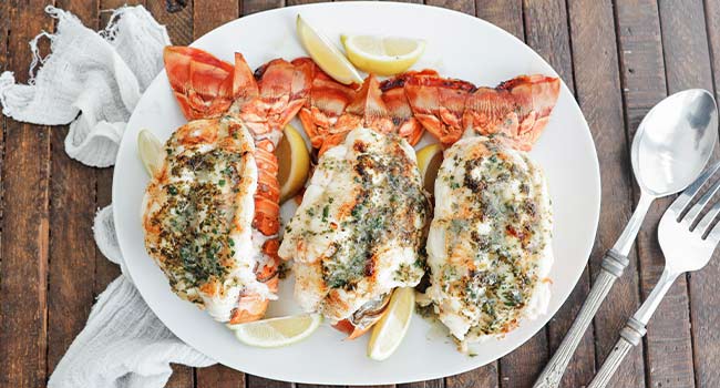 broiled lobsger tails with herb butter and lemons