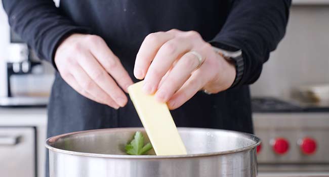 adding butter to a pot