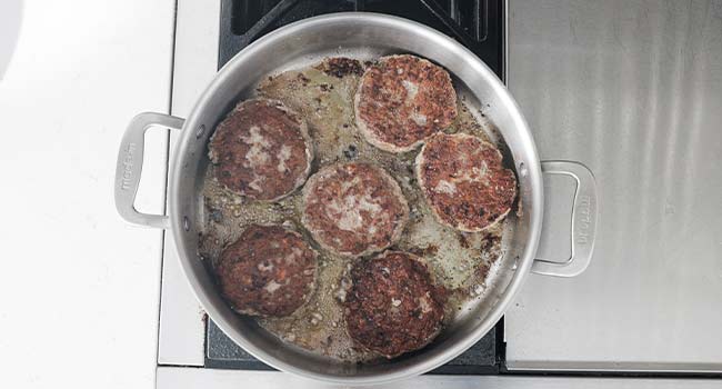 searing hamburger steaks in a pan