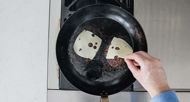 adding cheese to burgers