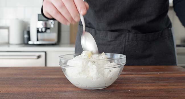 mixing together yogurt and garlic