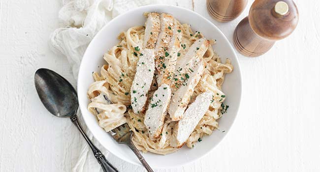 sliced chicken on fettuccine alfredo