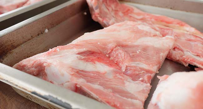 adding veal bones to a pan